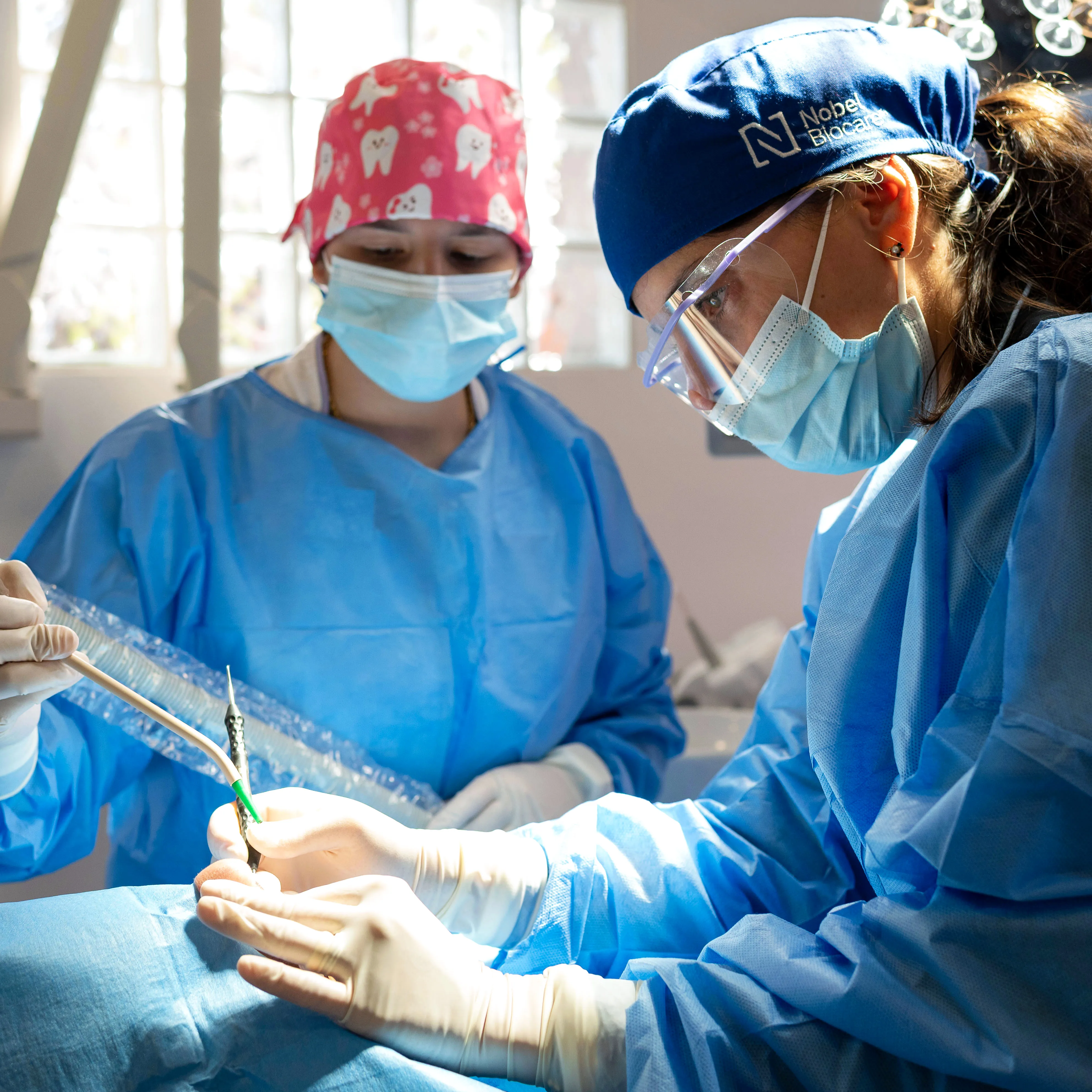 Procedimento clínico em periodontologia, com equipa médica a realizar tratamento gengival em ambiente clínico controlado.