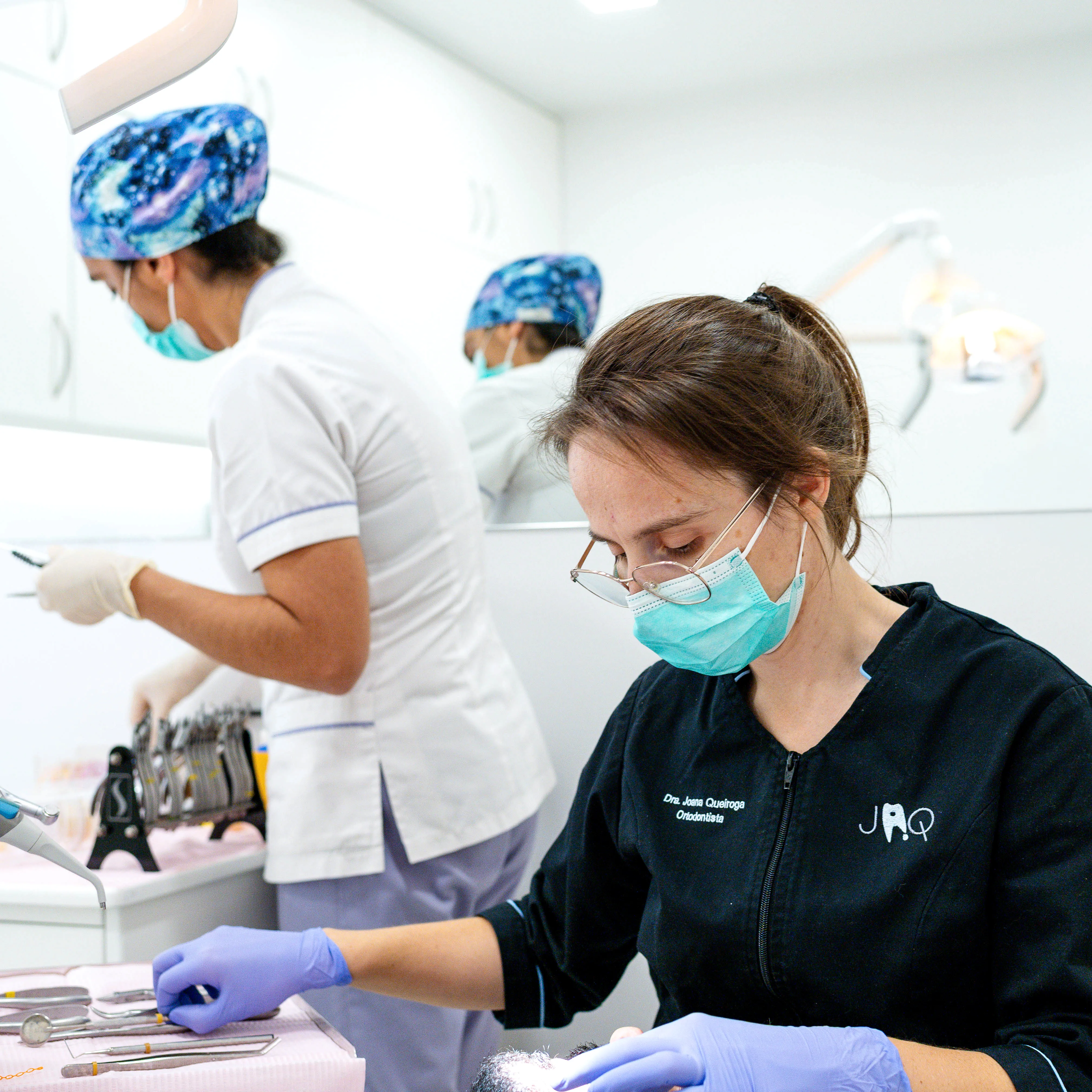 Ortodontista a preparar instrumentos durante consulta clínica de ortodontia personalizada.