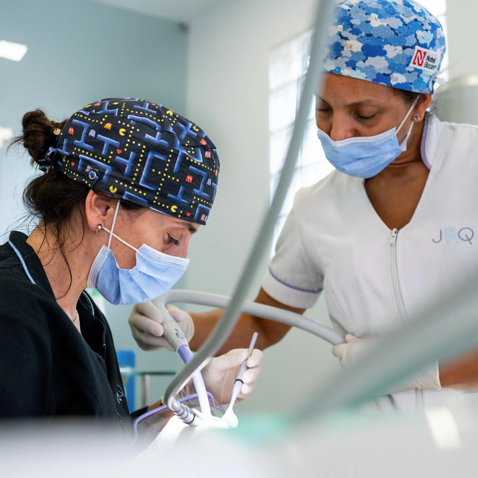 Profissionais de saúde oral a realizar tratamento dentário em ambiente clínico, com foco em precisão, cuidado e trabalho em equipa.