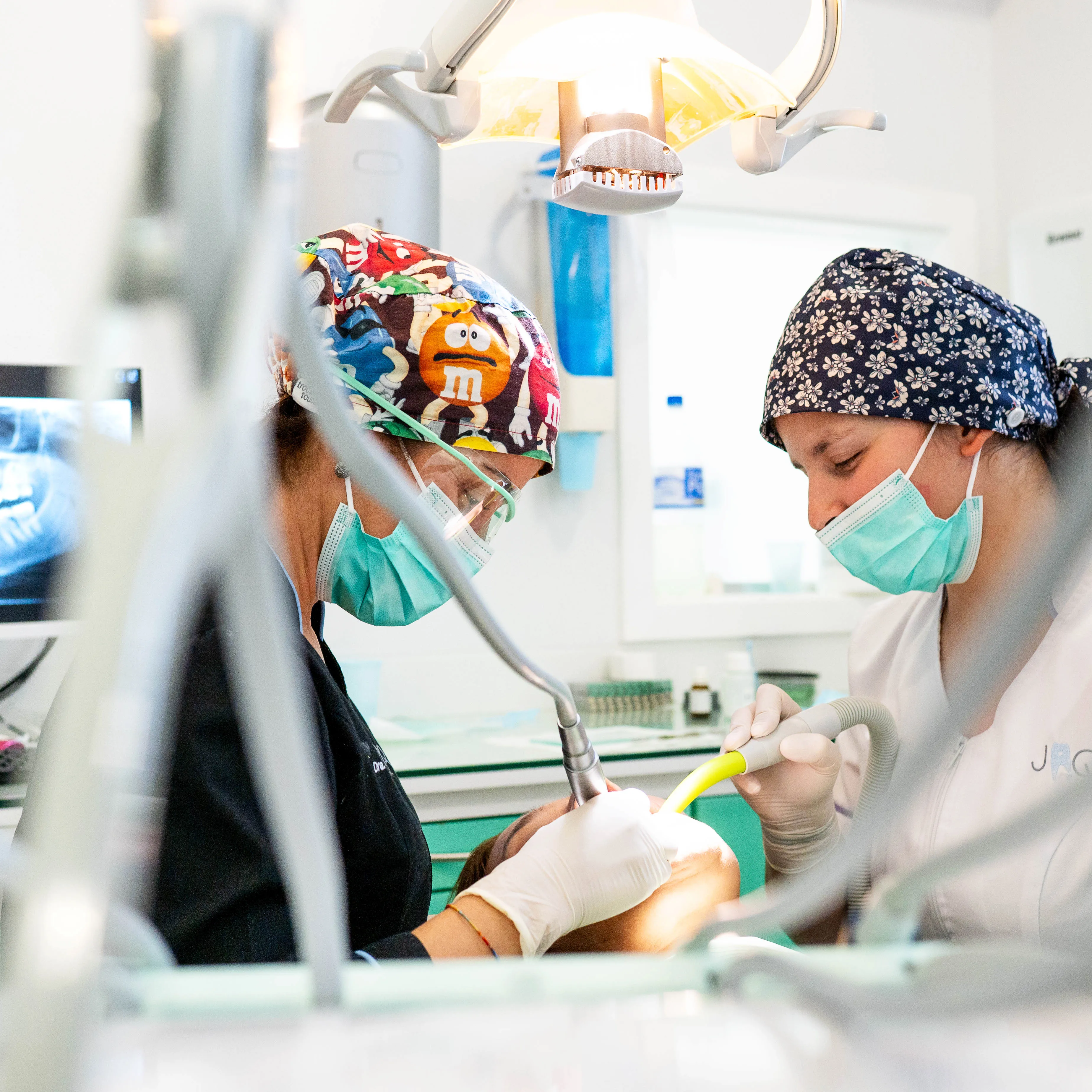 Equipa clínica a realizar tratamento dentário com acompanhamento próximo e rigor técnico.