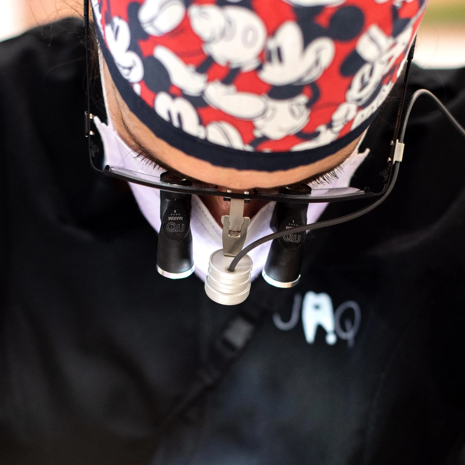 Profissional de saúde oral a utilizar lupas de magnificação com iluminação para realizar procedimentos dentários com elevada precisão clínica.