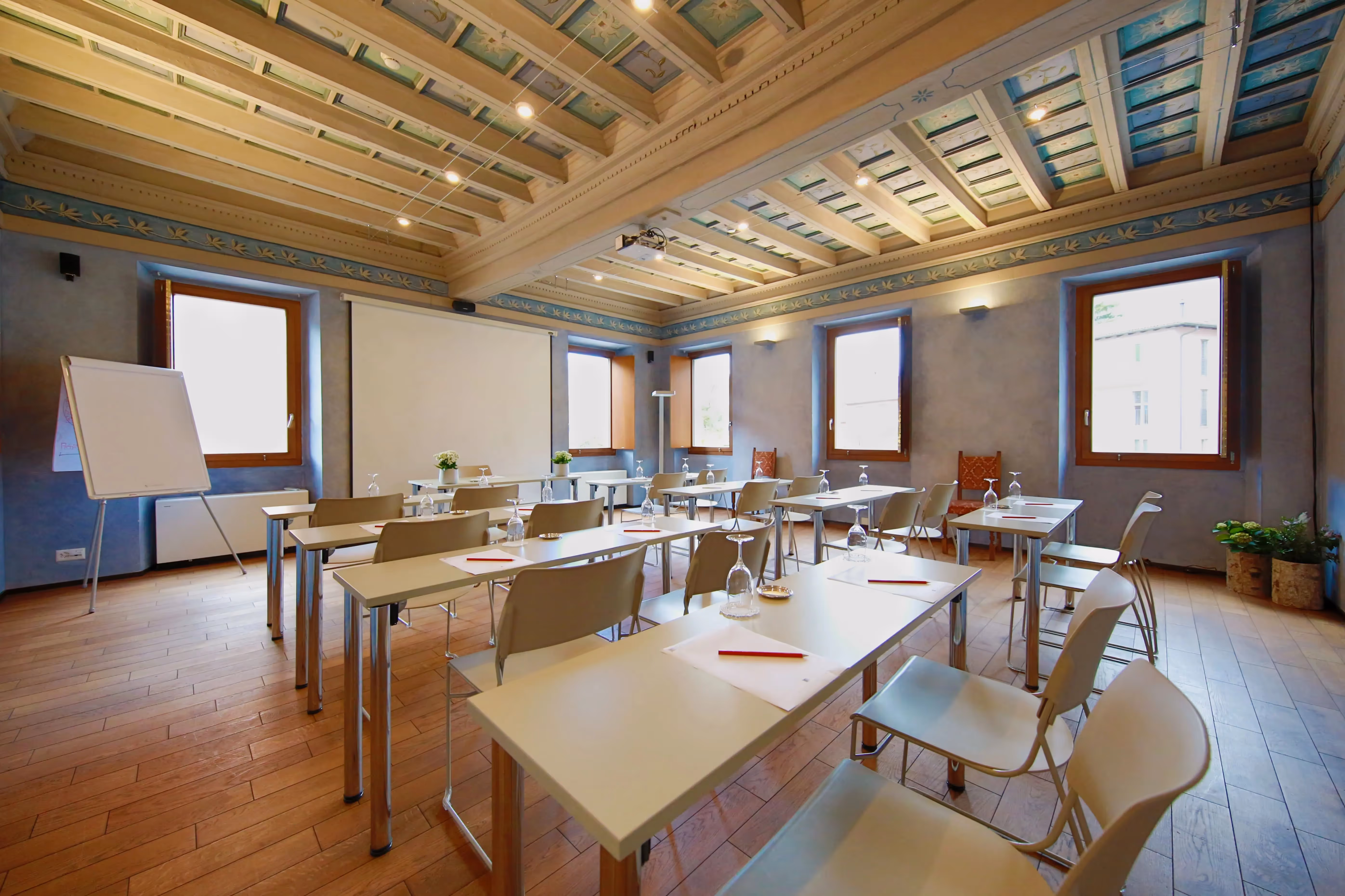 La Sala Nobile dell'Hotel La Tureta allestita per un evento, con tavoli elegantemente apparecchiati tra affreschi settecenteschi e soffitto ligneo a cassettoni.