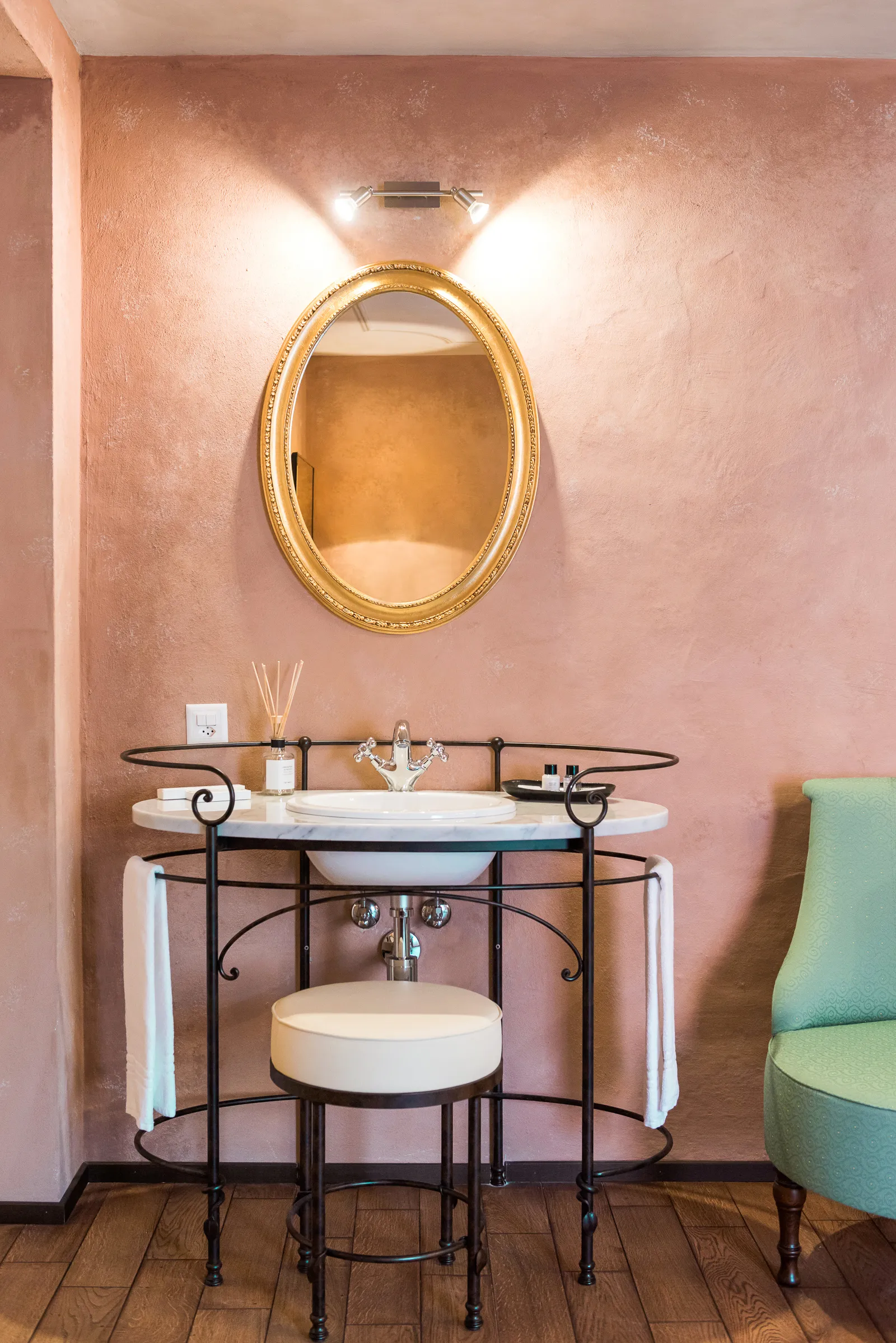 Salle de bain privée moderne de la chambre Unique avec carrelage effet pierre ; le grand miroir réfléchit le lit à baldaquin.
