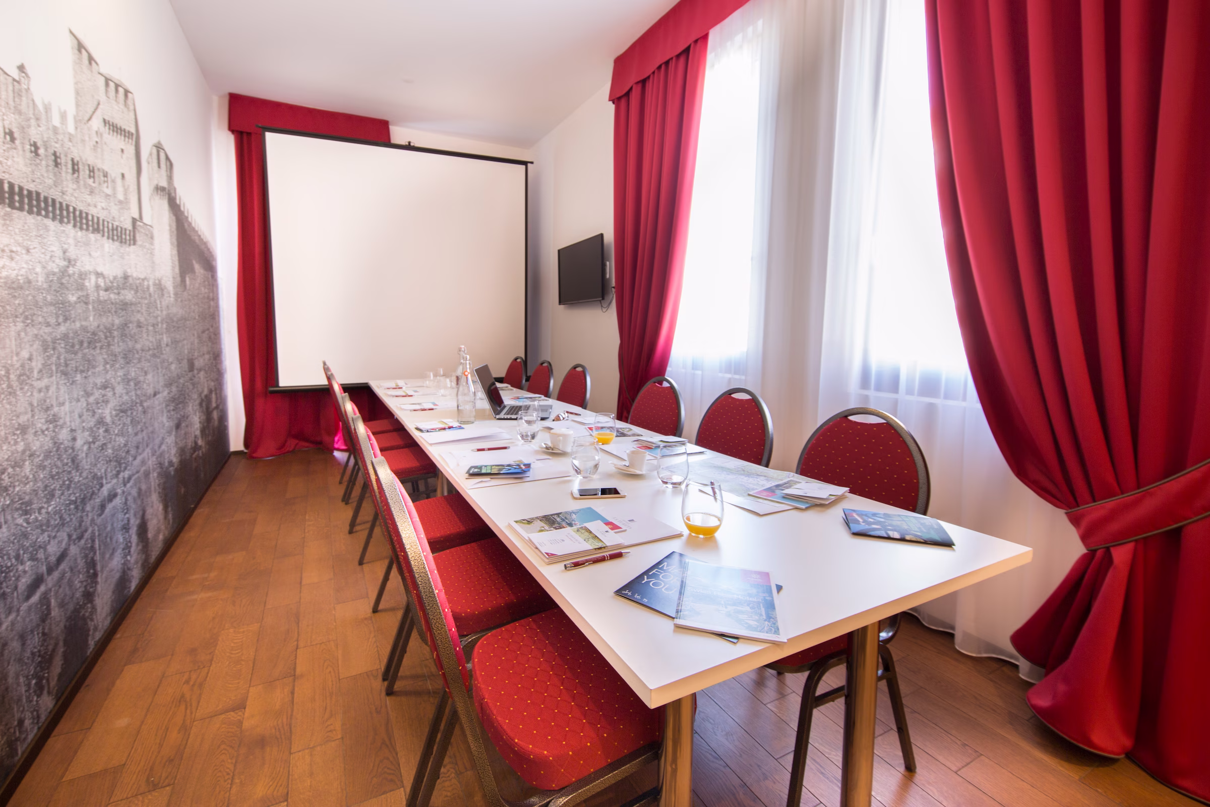 Sala Porpora für eine Veranstaltung mit roten Stühlen und eleganter Dekoration eingerichtet.