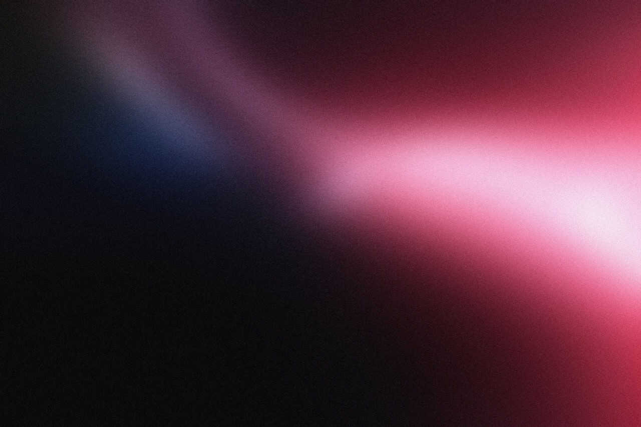 Abstract gradient background blending dark purple, blue, pink, and red colors with a smooth, soft texture.