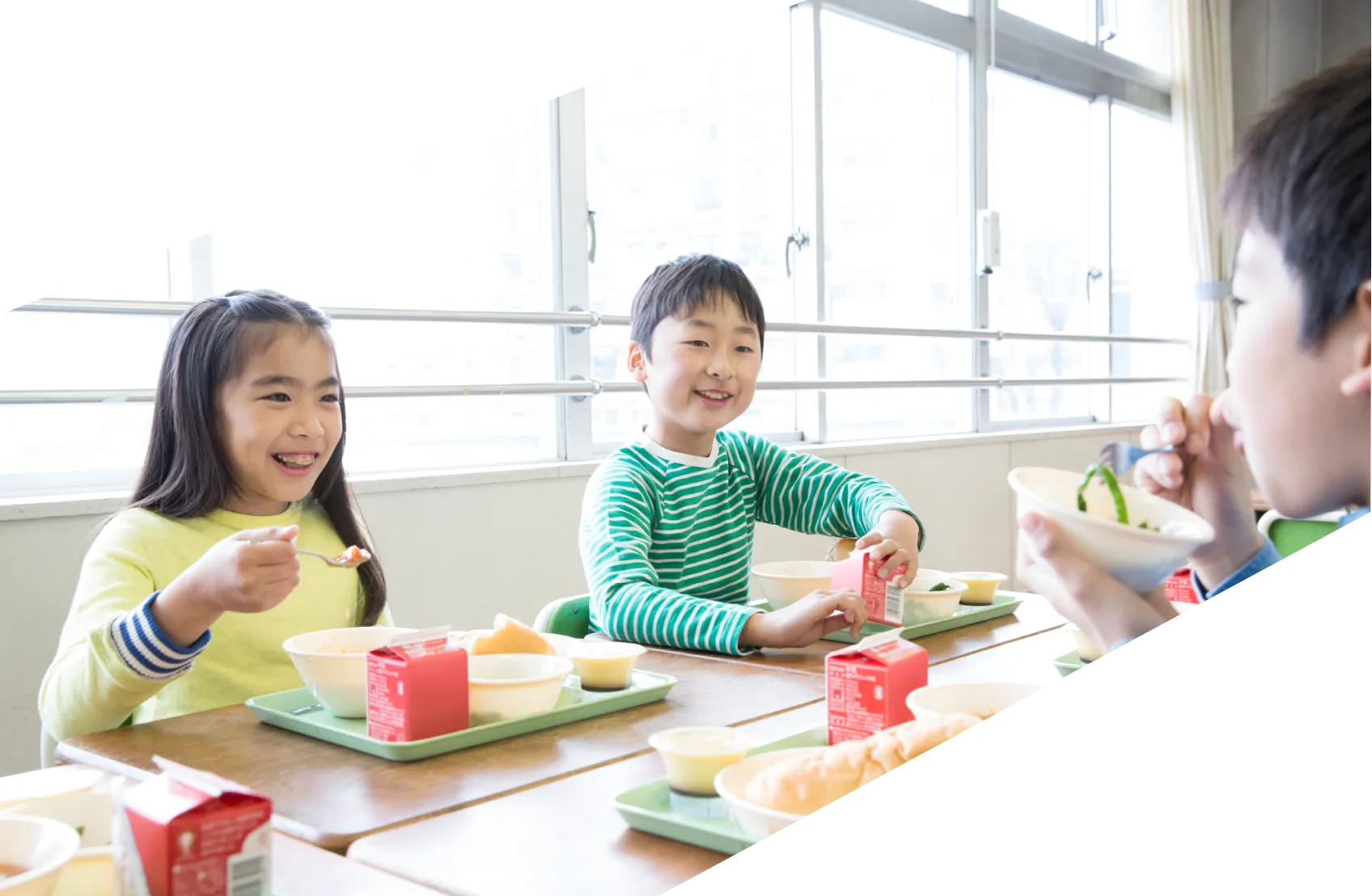 子供が楽しく給食を食べる様子