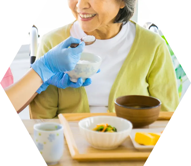 食事の介助をしてもらう女性