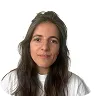 Portrait of a woman with long brown hair wearing a white top against a white background.