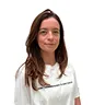 Smiling woman with long brown hair wearing a white top against a white background.