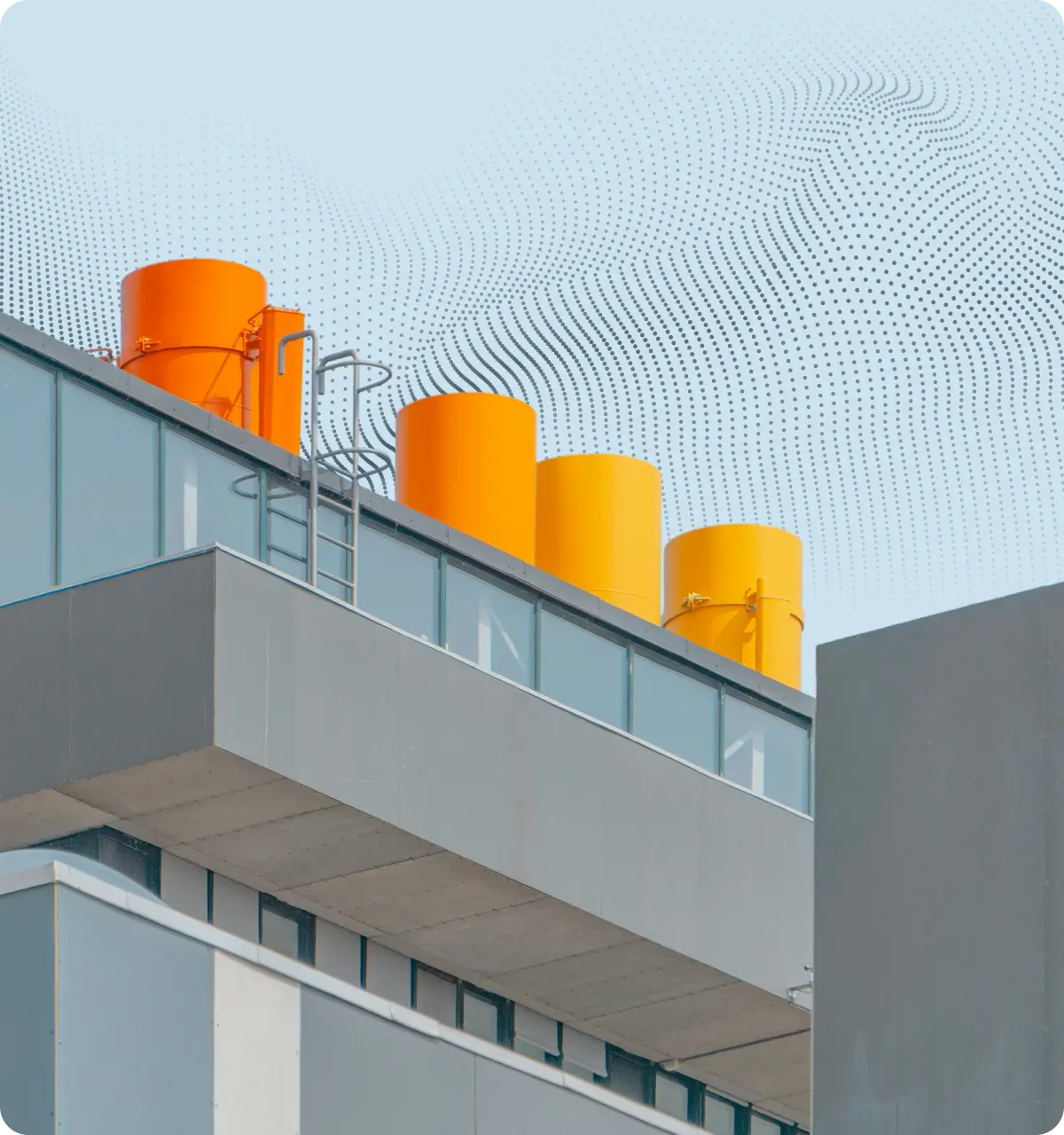 Modern building rooftop with four large orange cylindrical tanks and an attached metal ladder.