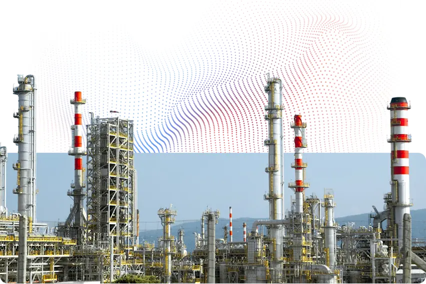 Industrial refinery plant with tall metal towers and red-and-white striped smokestacks under a clear blue sky.