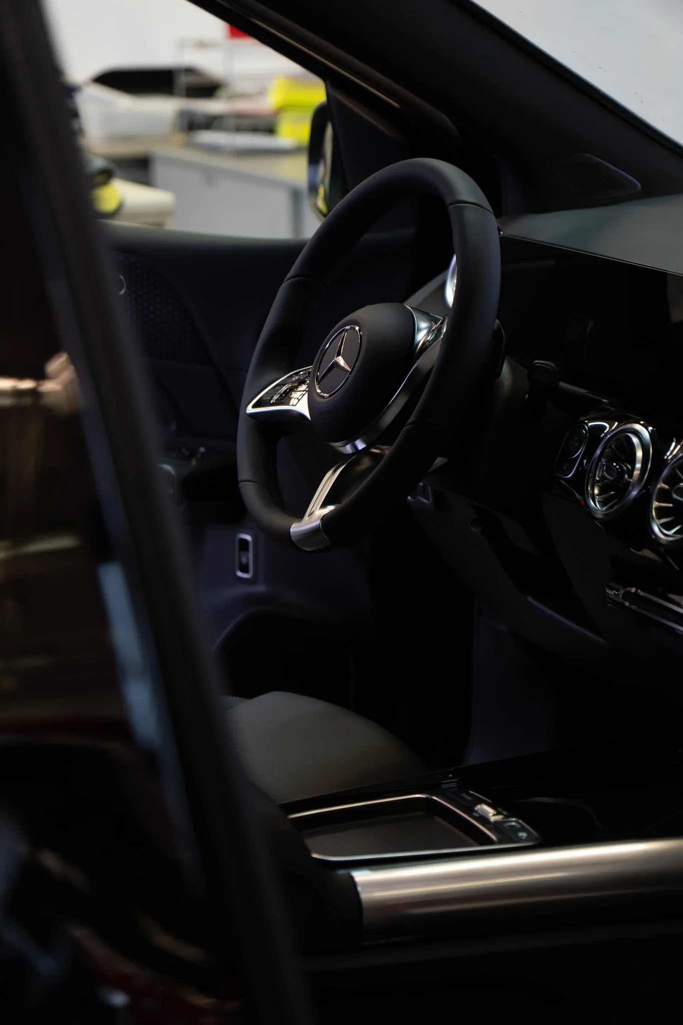 Innenraum eines Mercedes-Fahrzeugs mit Fokus auf das Lenkrad und das Armaturenbrett.