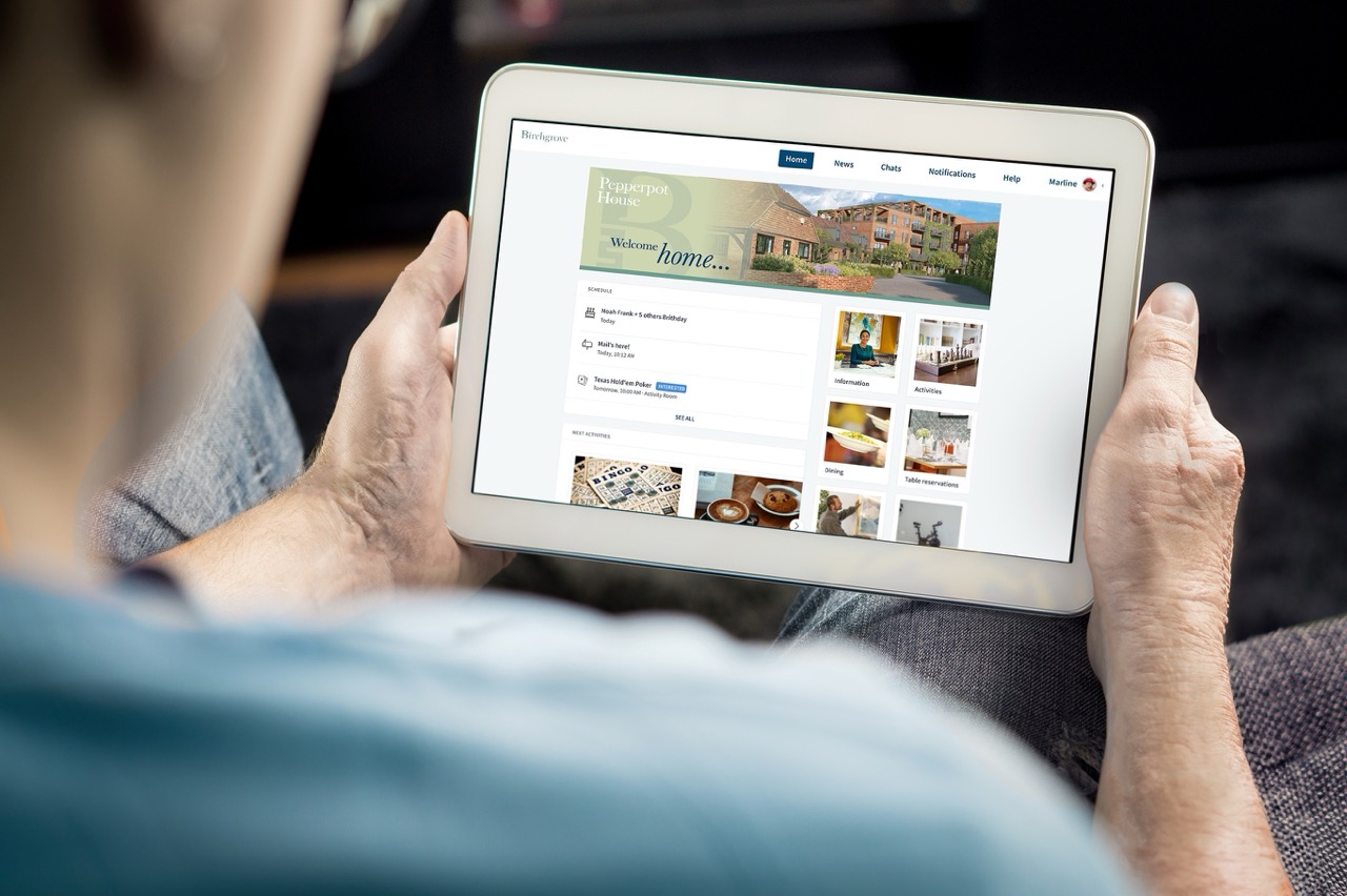 Person holding a tablet displaying a community app for Pepperpot House with schedule, activities, and reservation options.