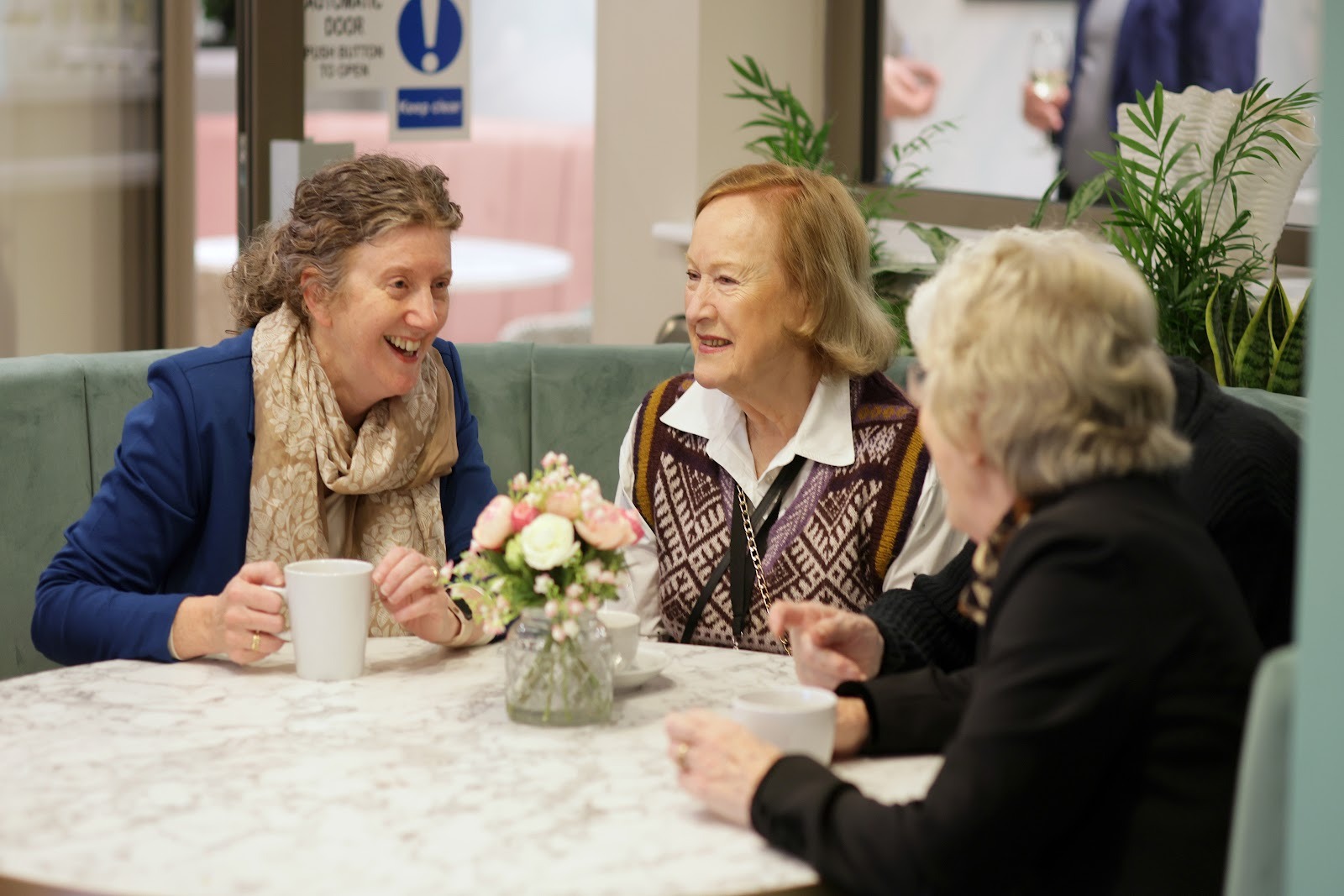 Three women connecting and chatting over tea at Birchgrove, a later living community