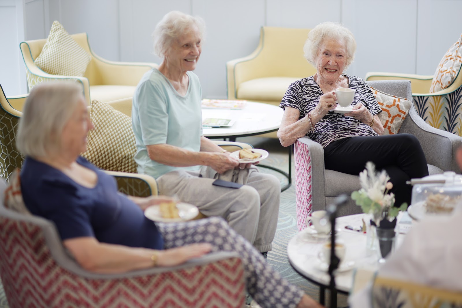 Neighbours chatting over tea and cake at Birchgrove Retirement Apartments in Ewell, Surrey, UK.
