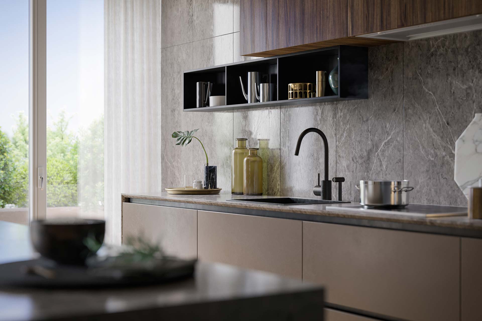 Cucina moderna con mobili beige, pareti in marmo grigio, lavandino nero con rubinetto alto, mensole nere con oggetti decorativi, vaso con foglia verde e piatto dorato sul piano di lavoro.