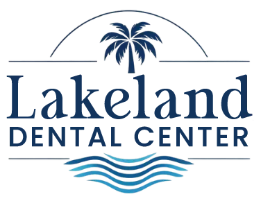 Lakeland Dental Center logo in dark blue, featuring a stylized palm tree above the practice name with three blue wave lines beneath, representing the dental office located in Lakeland, Florida.