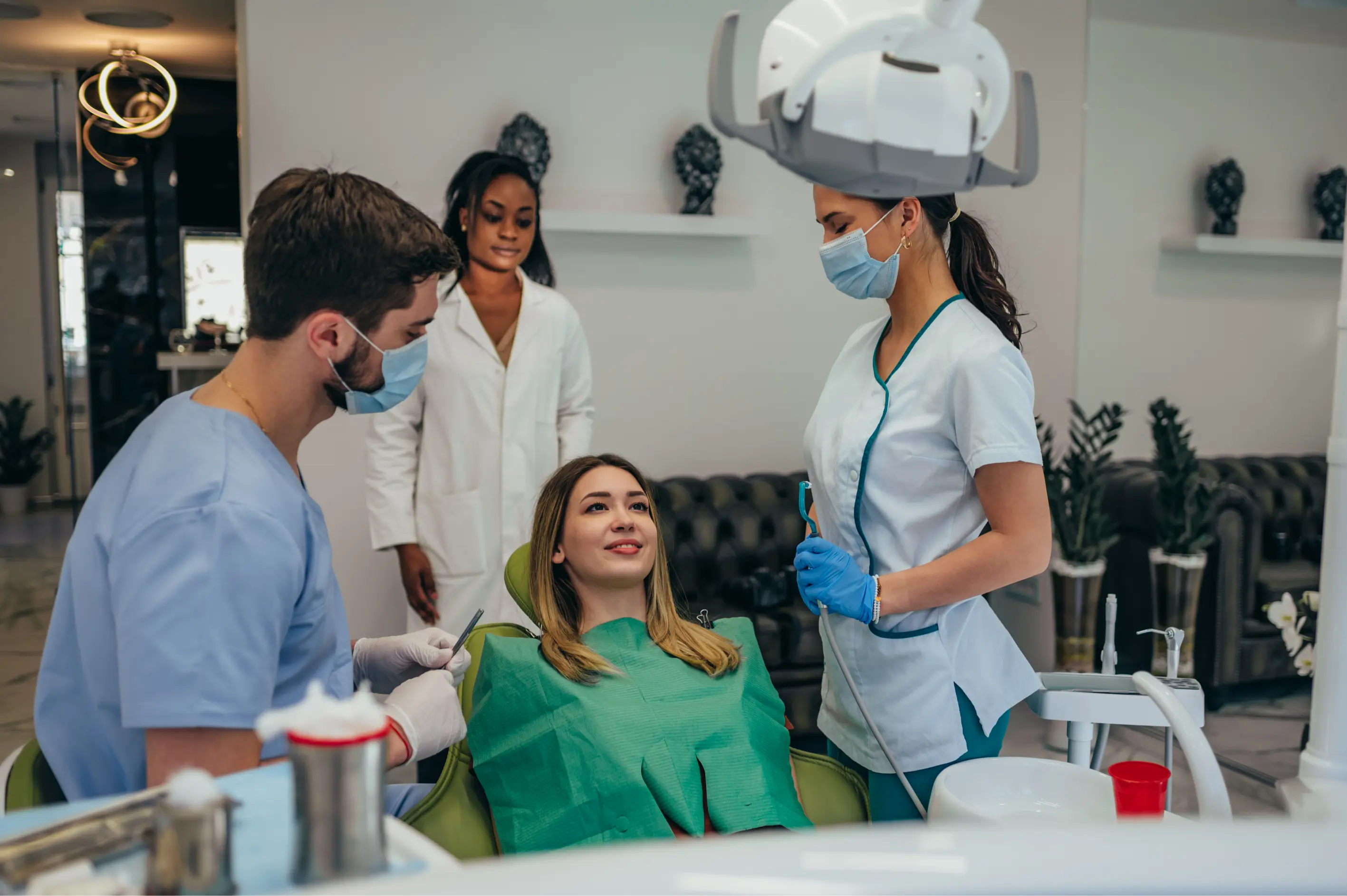 A dental team prepares a patient for routine imaging as a clinician positions a panoramic X-ray machine around the patient’s head during a general dentistry exam.
