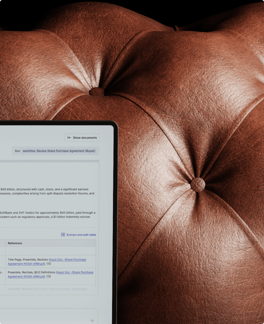 Close-up of a dark brown leather tufted surface with a partial view of a digital document displayed on a tablet screen.