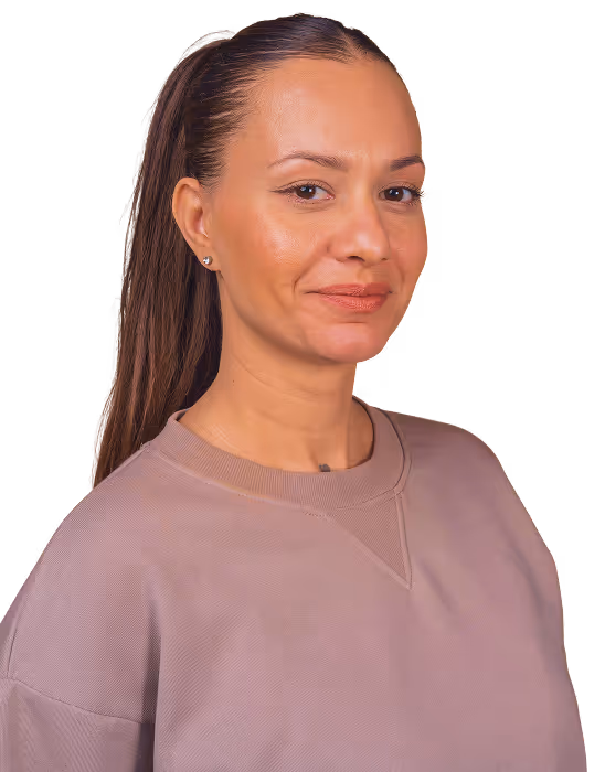 Woman with long brown hair tied back, wearing a mauve sweatshirt, smiling slightly against a transparent background.