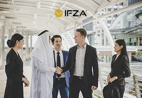 Professionelle Unternehmer bei einem Meeting, die positiv und strahlend Hände schütteln in Dubai vor einer hellen Kulisse, die sich außen befindet