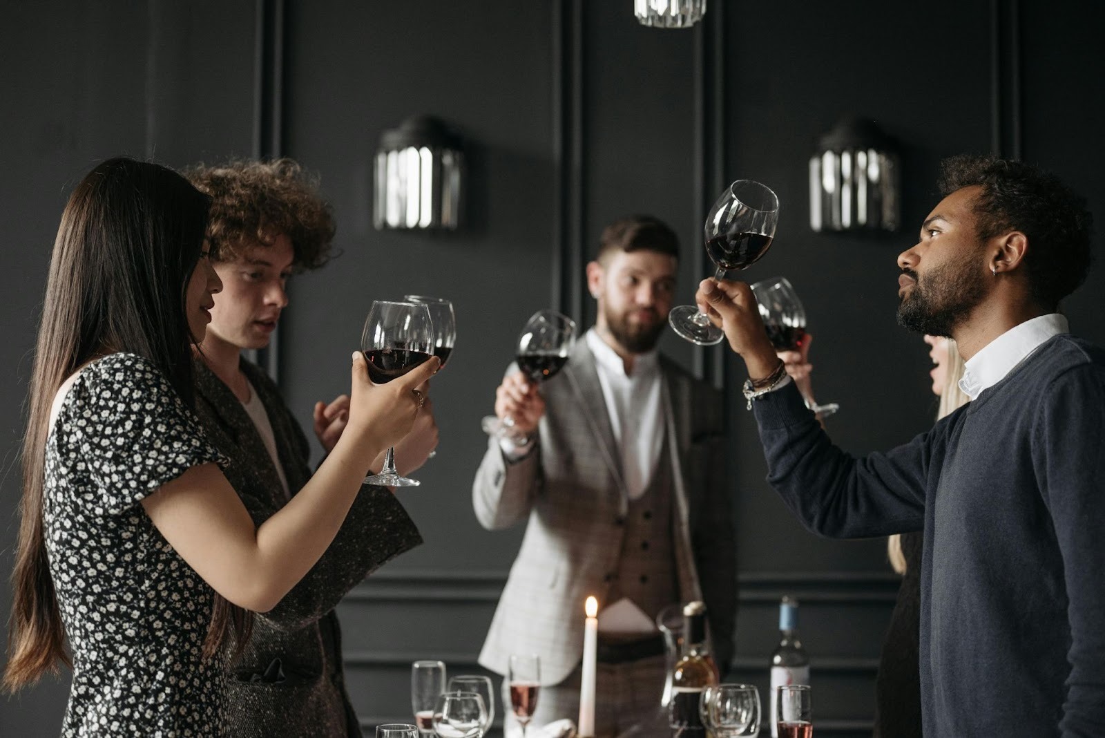 People have gathered for wine tasting session and each one is analyzing their glass of wine. 