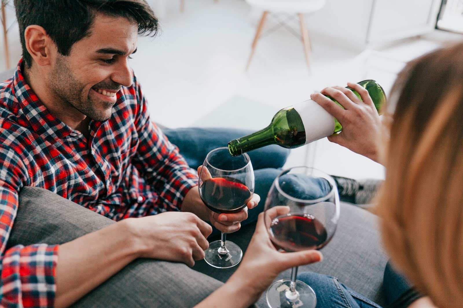 two friends enjoying wine on couch