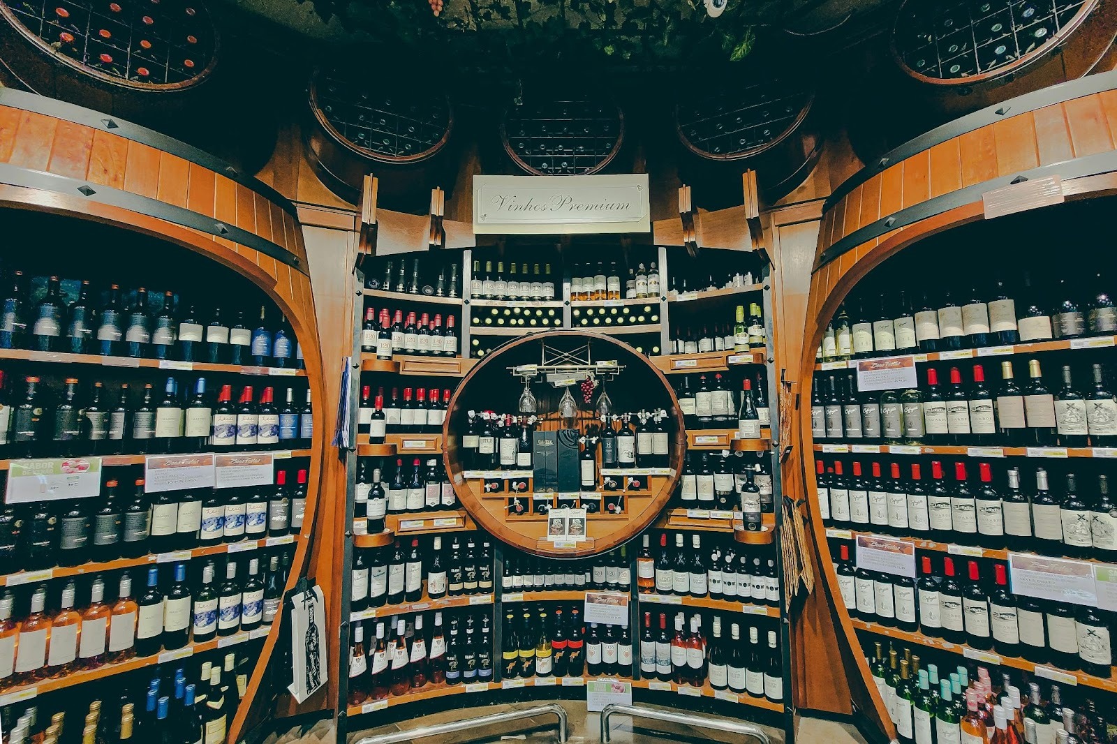 Lots of wine bottles in barrel shaped display