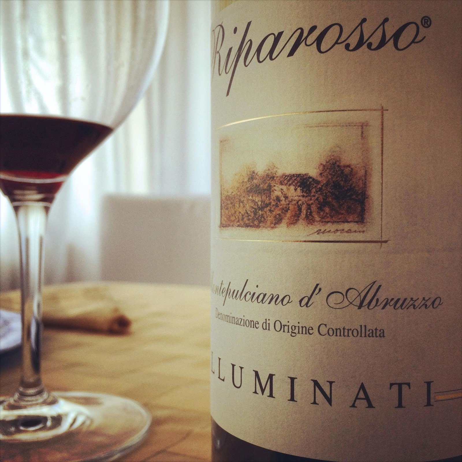 Montepulciano d’Abruzzo wine bottle and a glass of wine placed in a table