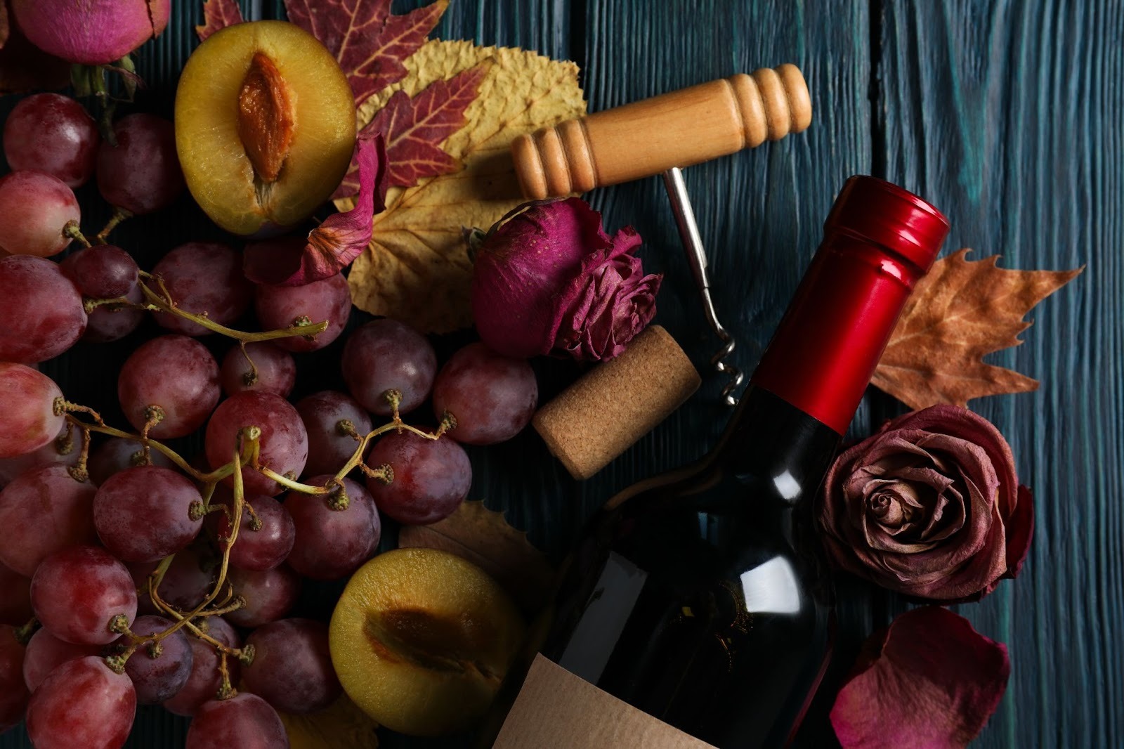 A wine bottle, a cork screw and wine ingredients 