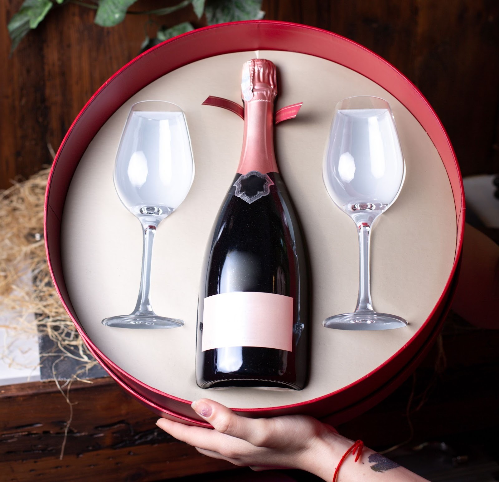 a round box containing a red wine bottle and 2 glasses
