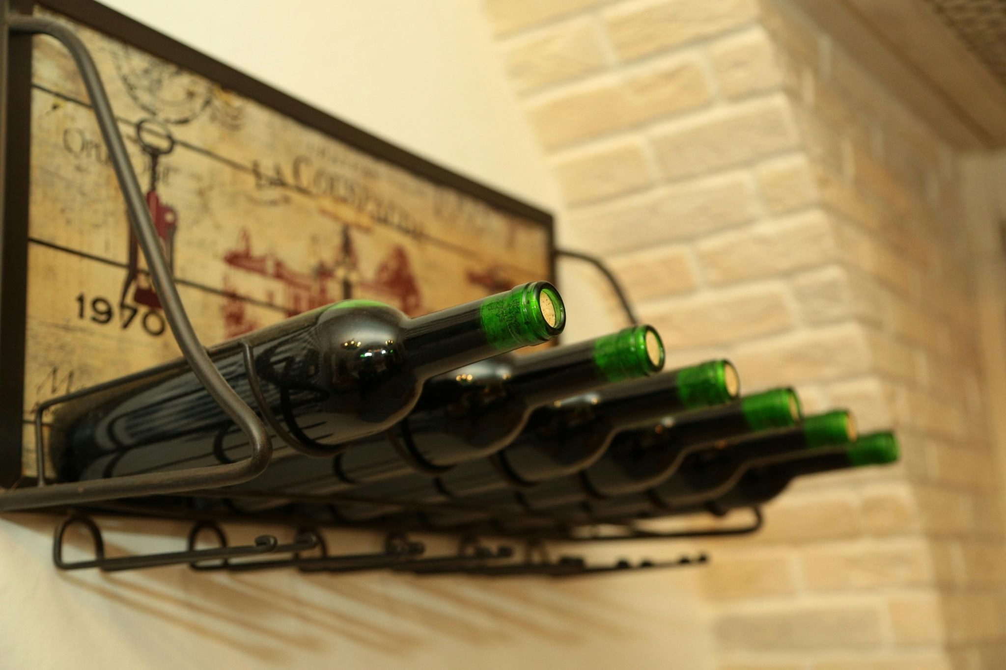 Green bottles lined in a shelf on wall