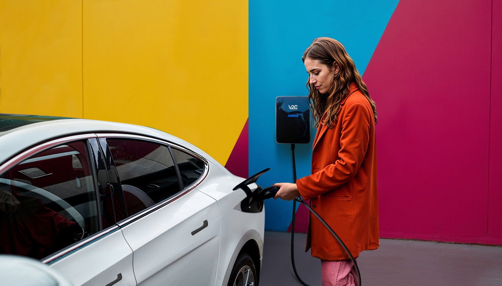 Photo d'une femme chargeant sa Tesla grâce à la borne V2C installé par les soins de Khematec Solutions.