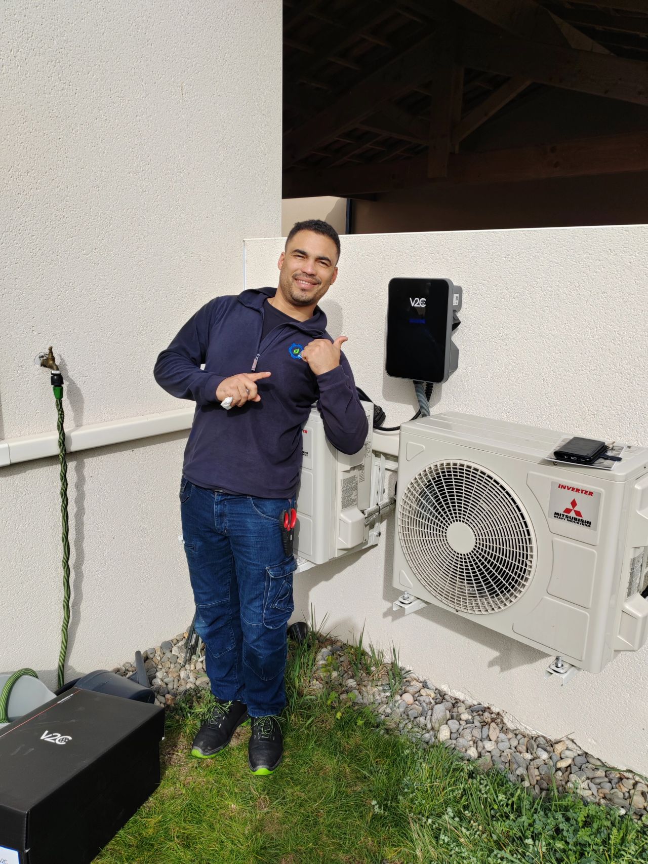 Photo de Ronmell, gérant de Khematec Solutions, à coté d'une borne V2C qu'il vient tout juste d'installer à Colomiers.
