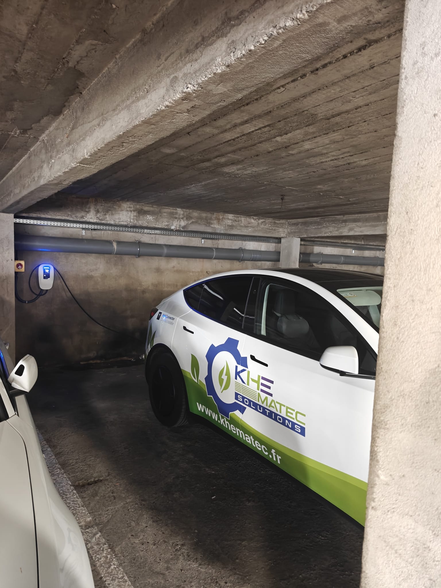 Photo de Ronmell, gérant de Khematec Solutions, à coté d'une borne V2C qu'il vient tout juste d'installer à Colomiers.
