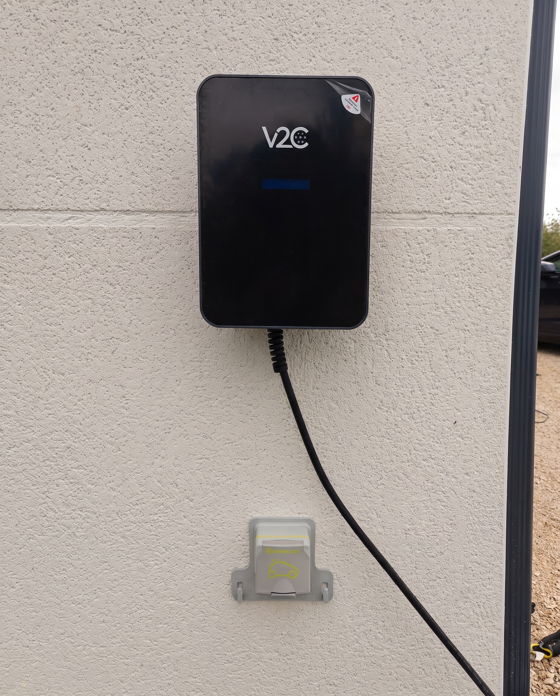 Borne de recharge murale noire sur crépi blanc, installation de borne de recharge à Balma par Khematec Solutions.