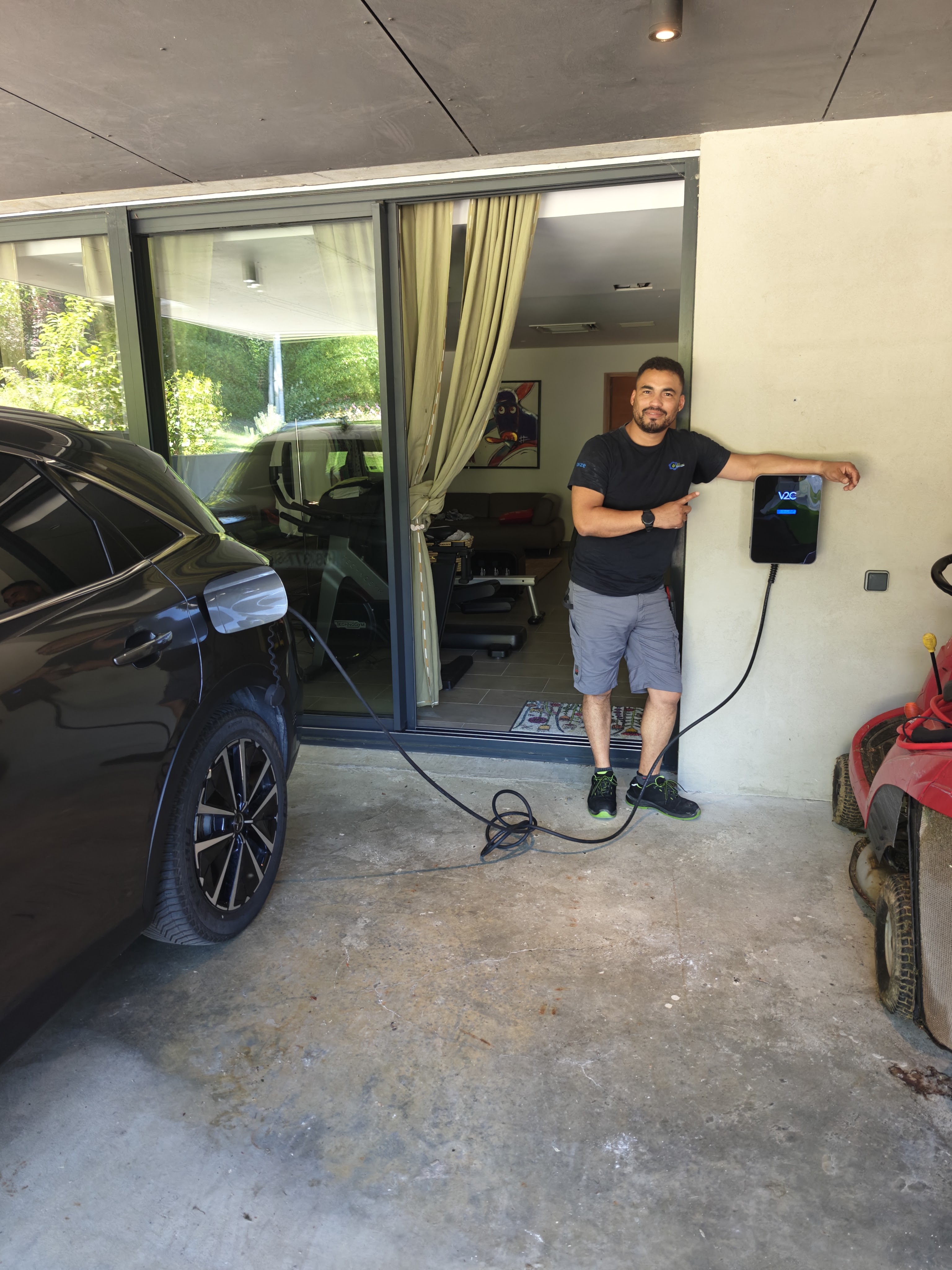 Installation de borne de recharge à Aucamville par Khematec Solutions, artisan devant un boîtier mural noir.