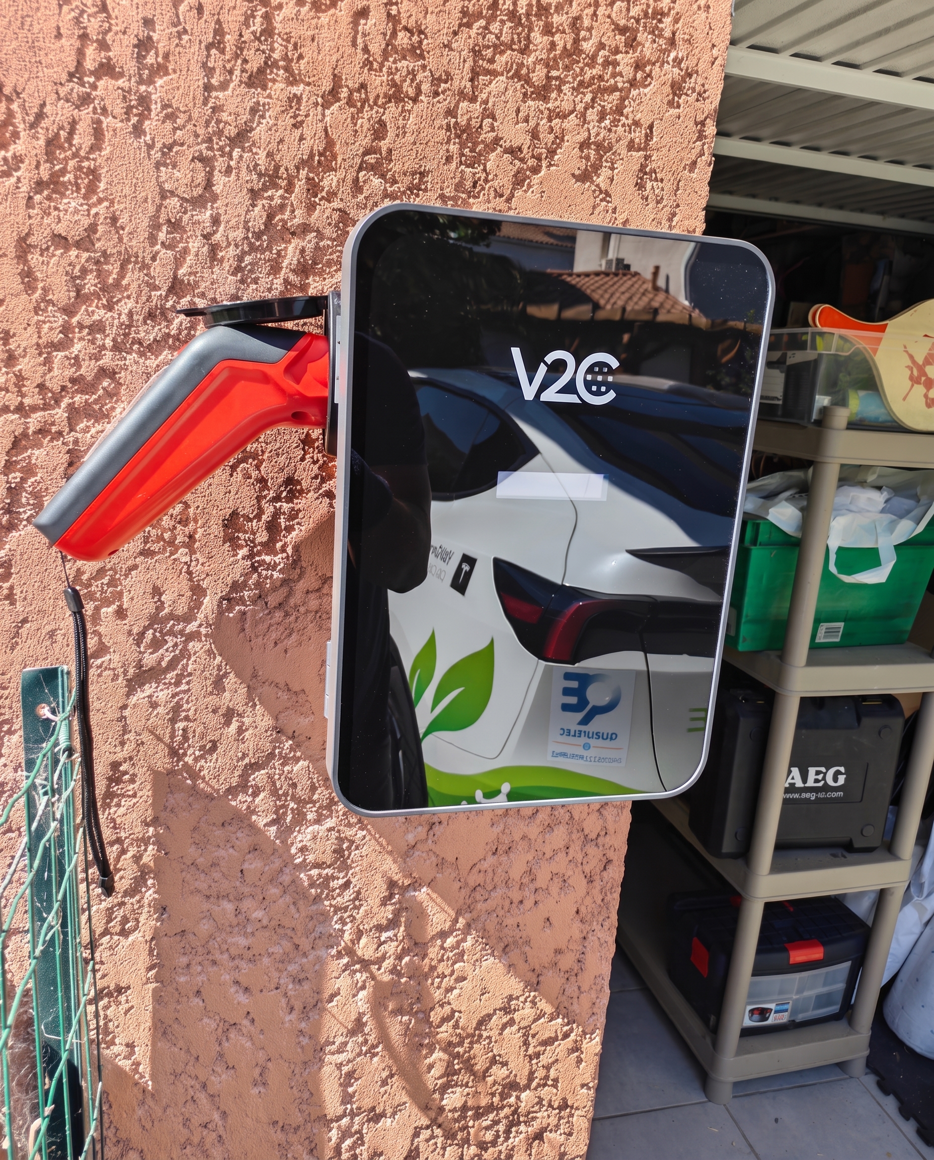 Installation de borne de recharge à Blagnac par Khematec Solutions, artisan devant une borne murale dans un garage.