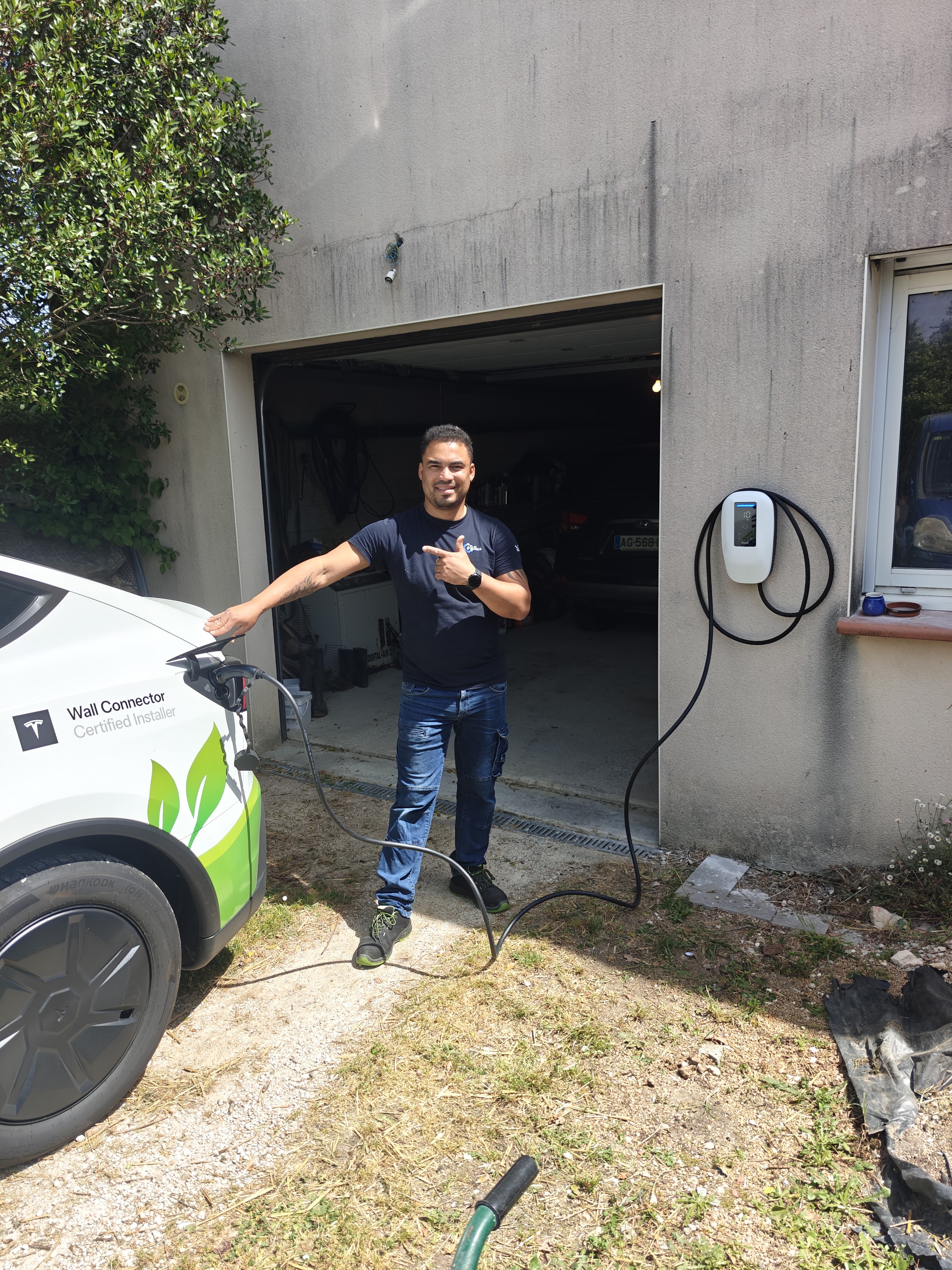 {"alt": "Installation de borne de recharge à Quint-Fonsegrives par Khematec Solutions avec borne murale noire et véhicule pro.