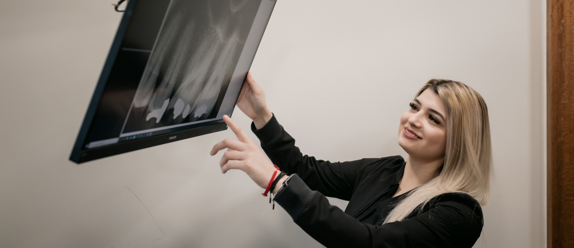 Hygienist showing client x-ray teeth on a screen