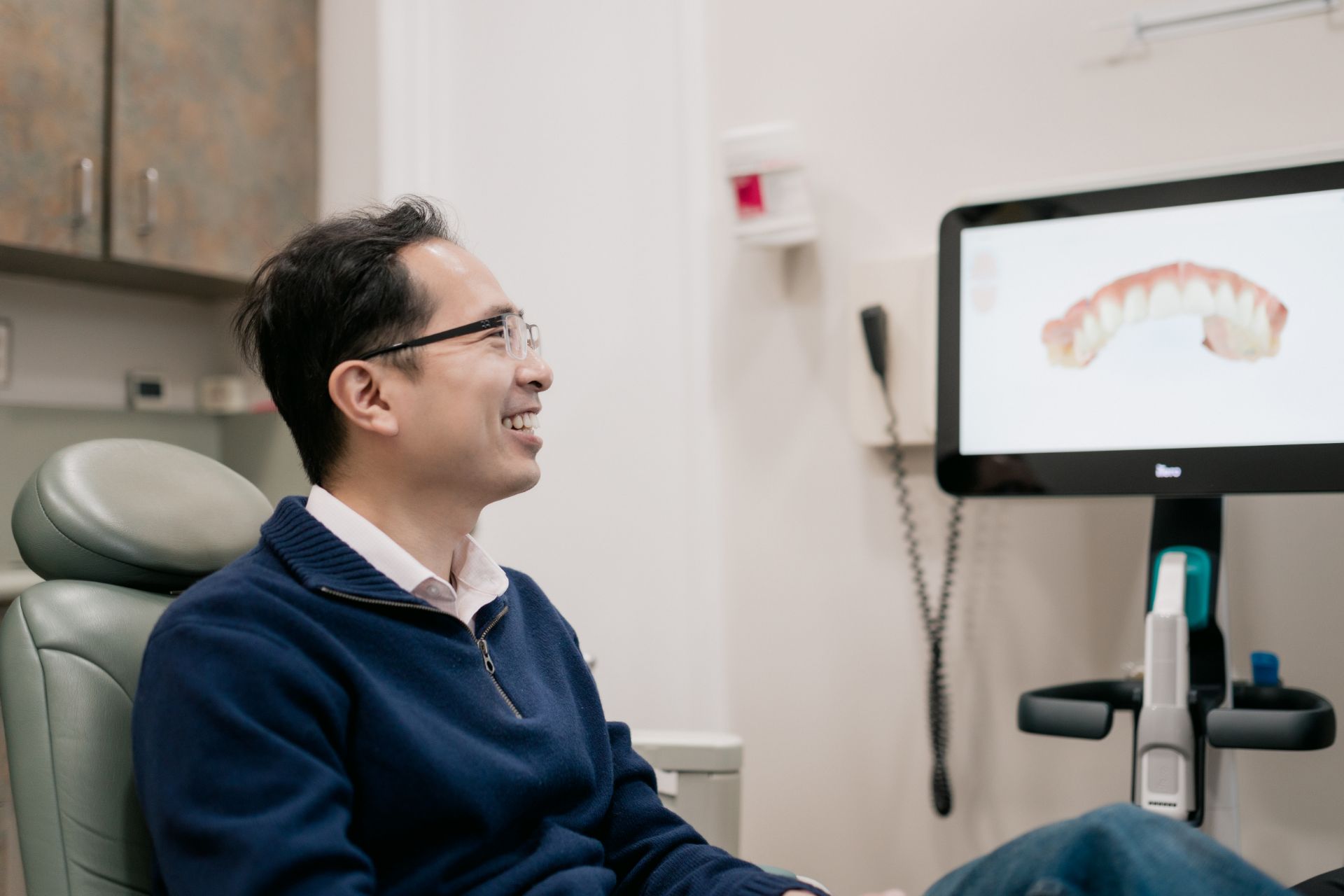 A patient looks at a 3d dental scan on a monitor