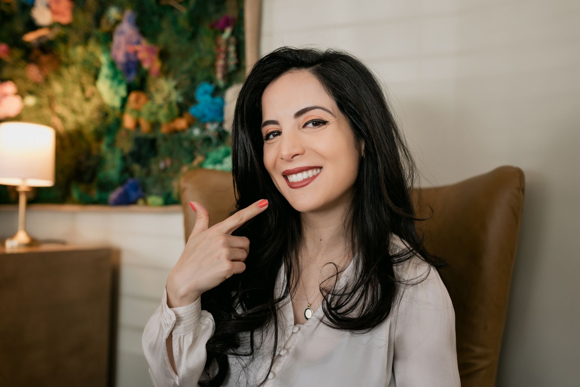 A woman points at her smile