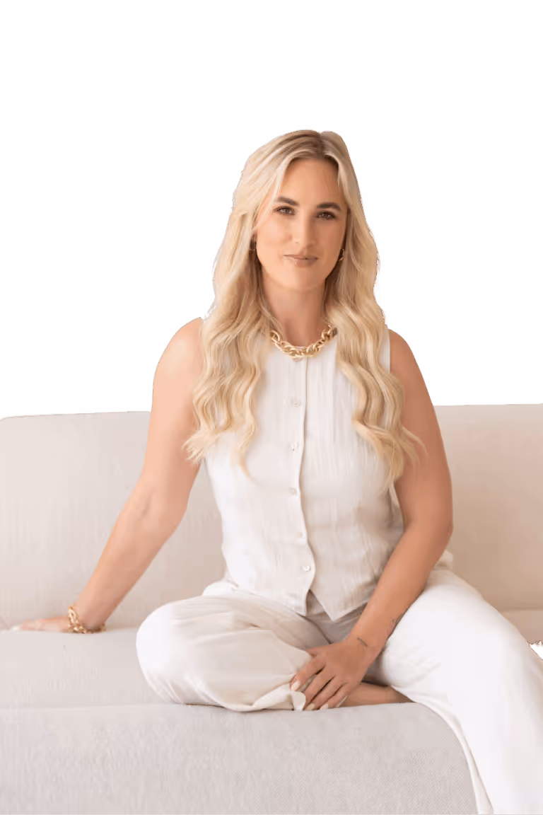 Hannah Medic sitzt entspannt auf einem Sofa und symbolisiert den sicheren Lifetime-Zugang zum HEAL Programm zur Nervensystem-Regulation.