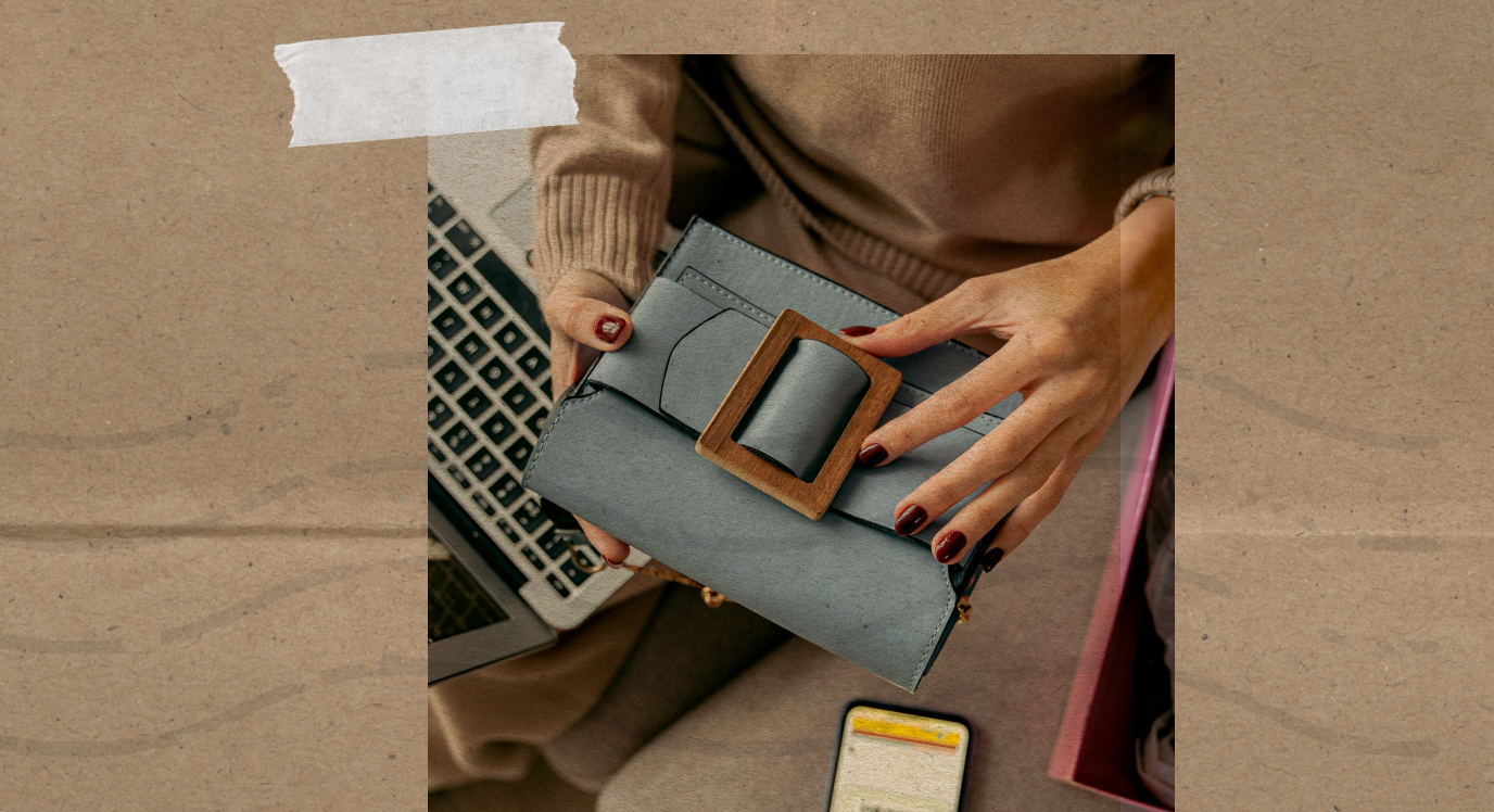 Hands holding a wallet beside a laptop and phone, highlighting Cyber Monday and Black Friday ecommerce strategies for checkout and payment readiness.