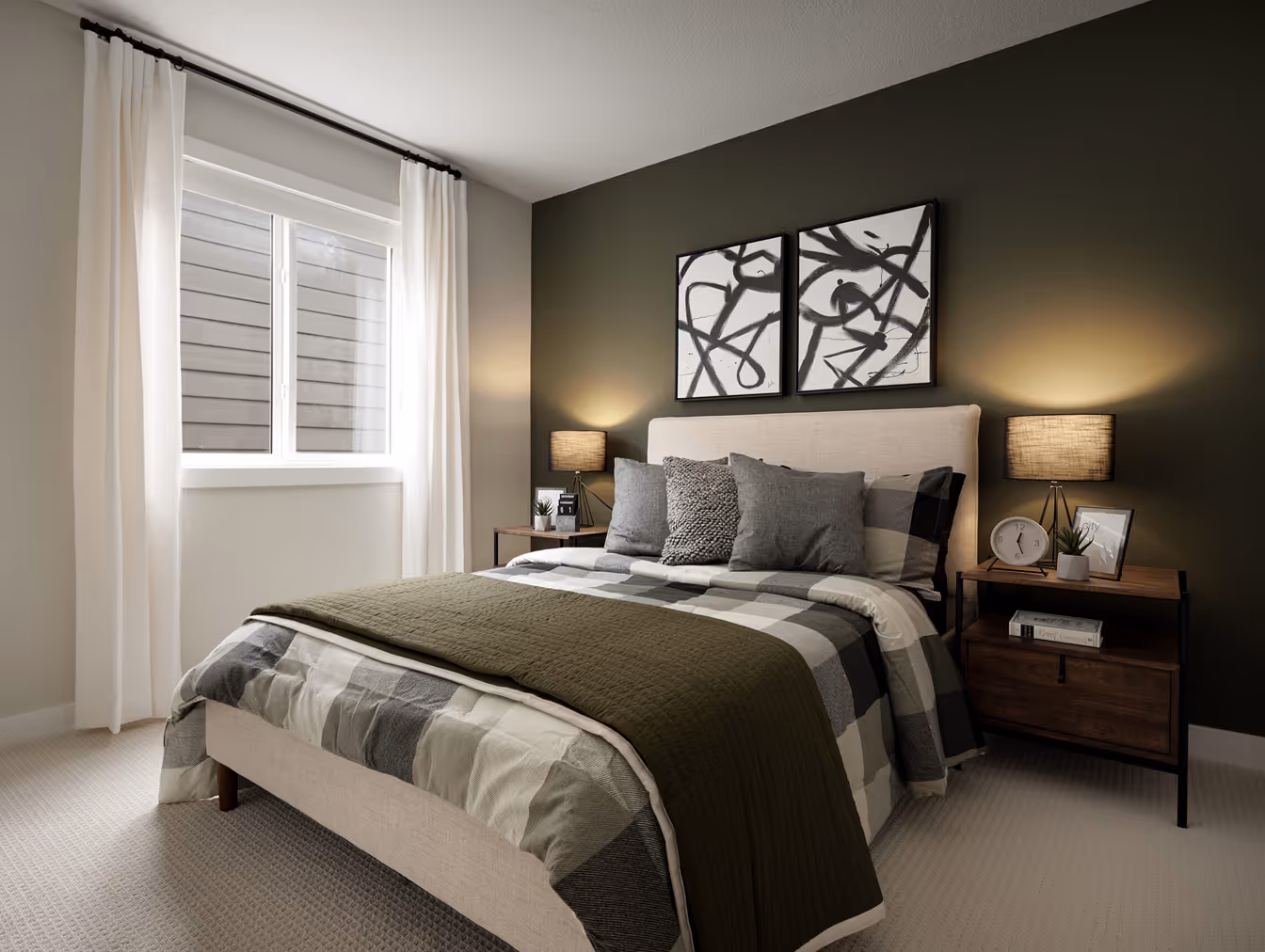Modern bedroom with a beige upholstered bed, gray and white checkered bedding, green throw, two bedside tables with lamps, and abstract black and white artwork above the bed.