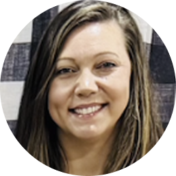 Smiling woman with long brown hair in front of a multi-colored checkered background.