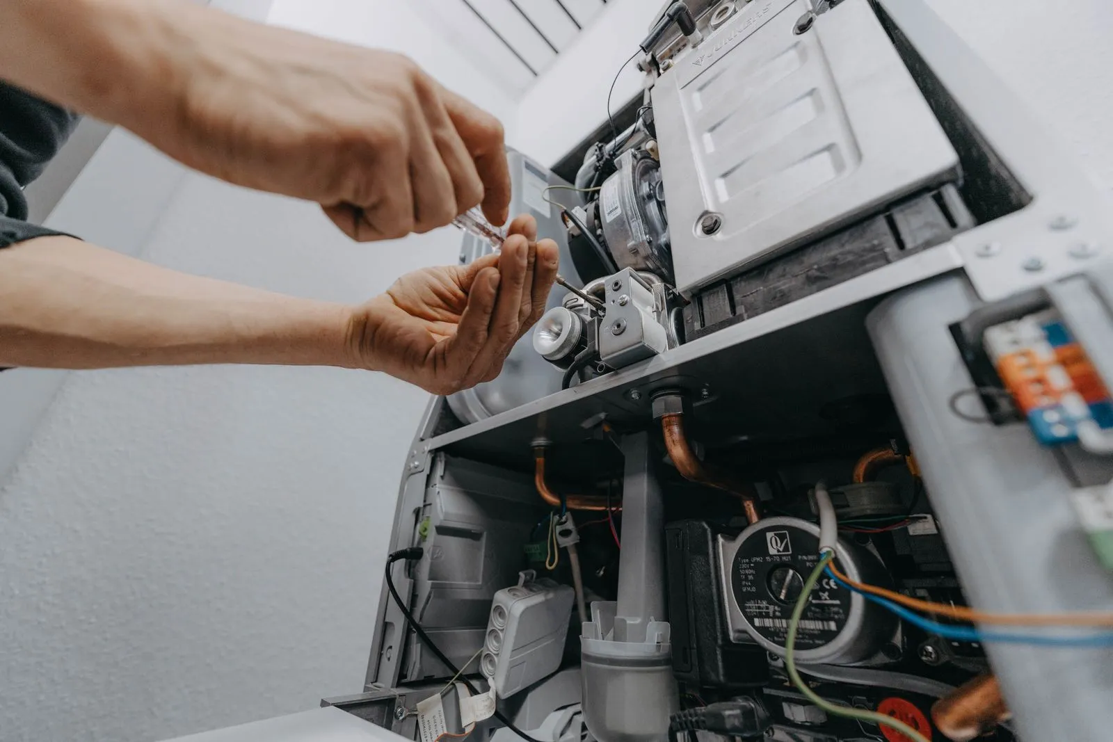 Nahaufnahme einer Heizungsreparatur durch Handwerker.