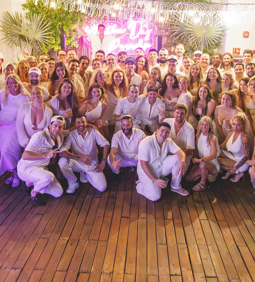 Group of young adults engaged in conversation at an outdoor event during the evening.