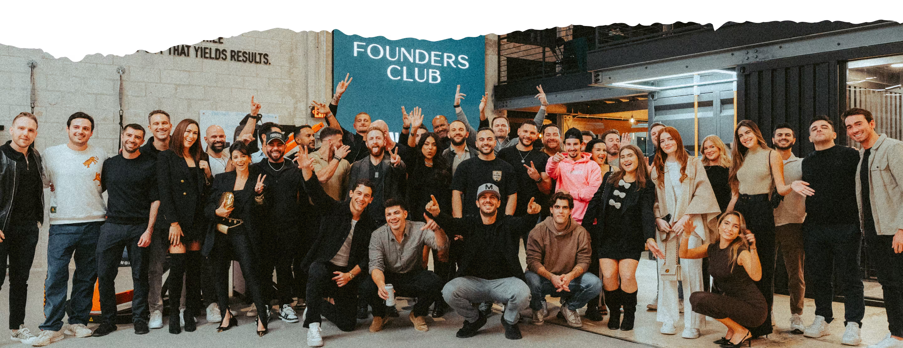 Group of men sitting at a table with drinks, one wearing a shirt that reads 'Rumble in the Jungle' with tiger images.