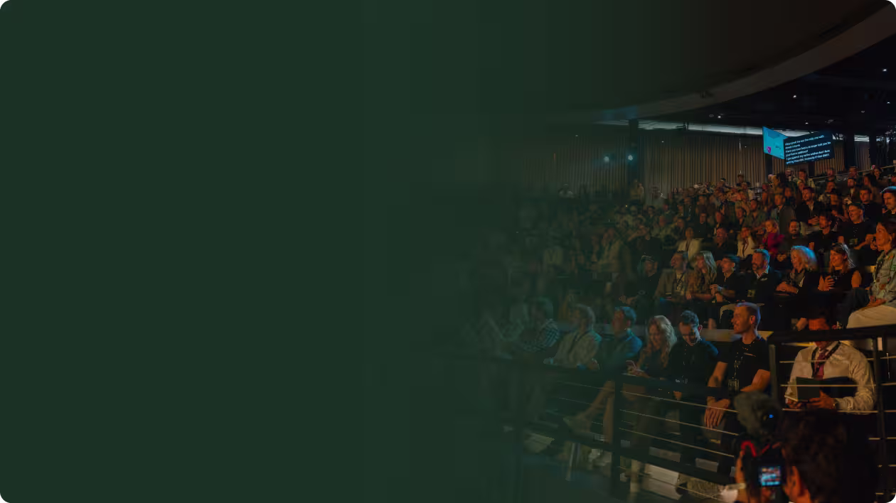 Three men in a warmly lit room laughing and engaging in a lively conversation.